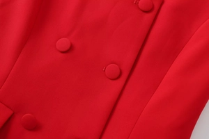 Dettaglio del tessuto rosso a trama con bottoni rivestiti coordinati e cuciture fini