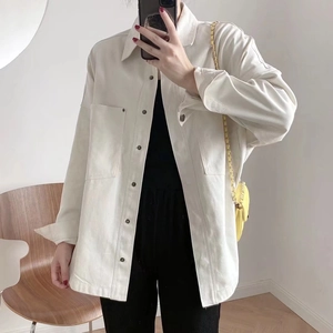 Detail of cargo-style beige denim jacket featuring symmetrical chest pockets and buttons