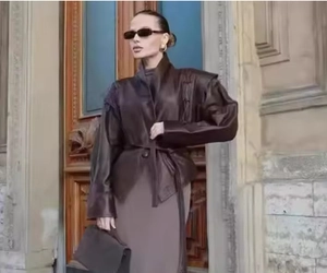 Détail de la veste vintage en cuir marron foncé avec épaulettes et ceinture à la taille