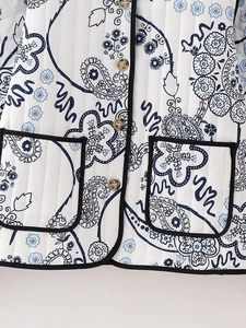 Close-up of vertical quilted paisley print jacket with black trim and brown buttons