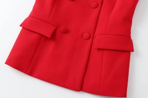 Dettaglio del gilet rosso con bottoni in tessuto a doppio petto e tasche con patta