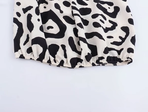 Detail des gesmokten elastischen Saums an einer schwarz-weißen Bluse mit Leopardenmuster