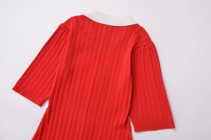 Détail d'une robe en maille rouge avec texture côtelée et col blanc contrastant