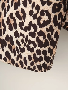 Detailed macro view of classic leopard print texture on a stylish autumn blazer fabric