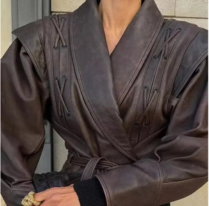 Détail d'une veste en cuir marron vintage avec lacets croisés tissés et taille ceinturée