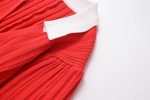 Détail du haut en maille rouge avec texture à rayures verticales et col à revers blanc