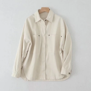 Detail of beige corduroy jacket showing large utility pockets with metal rivet accents