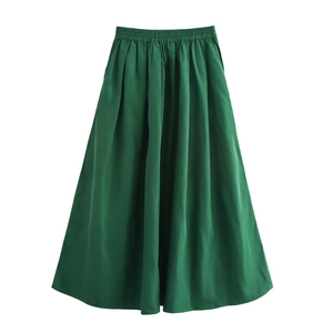 Détail d'une jupe midi vert foncé en satin brillant avec une taille haute élastique