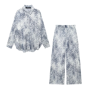 Close-up of snake skin print texture and collar label on women's shirt and trousers set