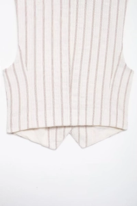 Close-up of pinstripe vest showing textile texture and pointed hem detail