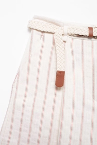 Detailed macro view of striped high-waisted shorts with cream braided belt and leather tips