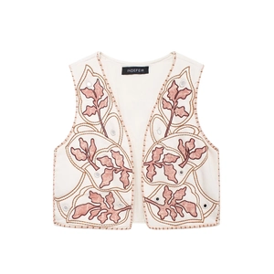 Dettaglio del ricamo effetto specchio e motivo foglia con paillettes su gilet beige