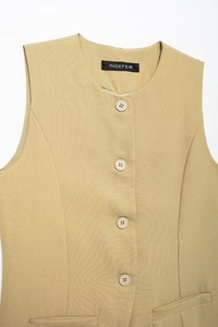 Détail de veste sans manches kaki montrant les boutons, les coutures et les poches