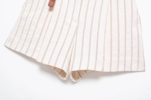 Detailed macro view of the cream fabric texture and red vertical stripes on the high waist shorts