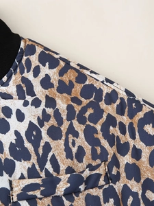 Close-up of leopard print jacket with black ribbed collar and textured fabric detail