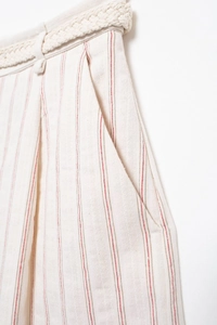 Detail of off-white striped shorts featuring a braided rope belt and functional side pockets