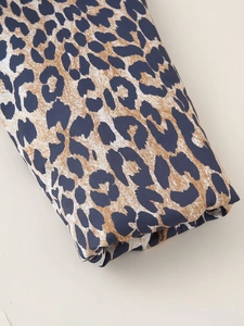 Detailed close-up of leopard print cotton jacket fabric with blue and tan patterns
