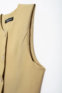 Détail d'un gilet sans manches kaki avec boutons et étiquette de col INDEFEIR