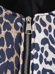 Macro shot of silver metal zipper and black ribbed collar on leopard print jacket