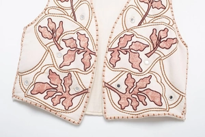 Dettaglio del gilet boho crema con ricamo a foglia rosa e decorazioni a specchio