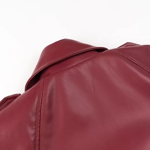 Gros plan du col et de l'épaule d'une veste en cuir bordeaux avec coutures précises