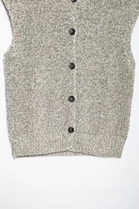 Detail of grey melange cotton knit vest featuring five dark round buttons and texture