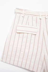 Detail view of high-waisted red striped shorts with a woven rope belt and flap pocket