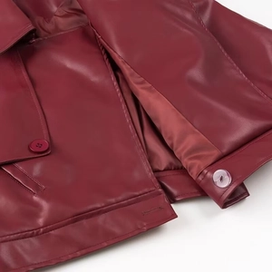 Vue macro détaillée d'une veste en similicuir bordeaux avec boutons et coutures de qualité