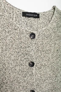 Detail view of cotton knit vest showing refined black and white texture and inner brand label