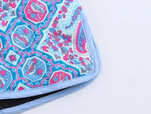 Détail du gilet matelassé avec motif paisley coloré et bordure décorative bleu clair