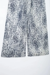 Detailed close-up showing grey python print pattern on women's high-waist wide-leg trousers