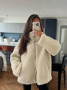 Détail de la texture polaire sherpa beige avec fermeture éclair double et grandes poches