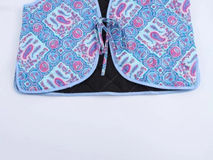 Vue détaillée du gilet matelassé à imprimé paisley avec fermeture à nouer devant