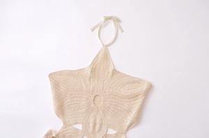 Detail of bohemian cream crochet halter dress featuring intricate hollow out flower patterns