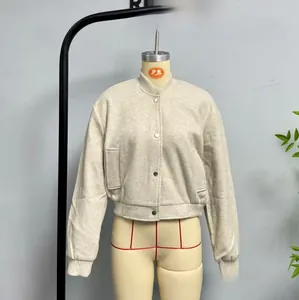 Detail view of light beige bomber jacket with large patch pockets and snap closure