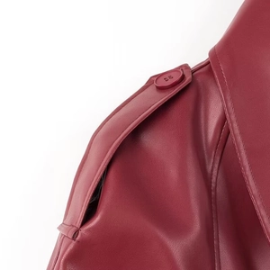 Gros plan sur l'épaulette et les coutures d'une veste en cuir bordeaux