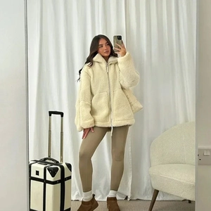 Détail de la veste à capuche en polaire crème avec fermeture éclair et grandes poches