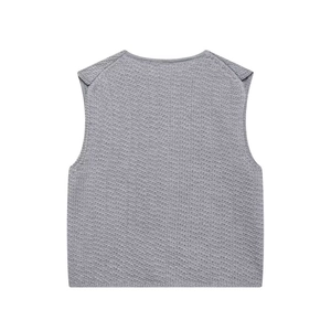 Détail du gilet en tricot gris clair montrant la texture alvéolée et le tissu de qualité