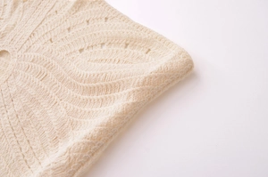 Close-up detail of cream knit halter dress showing intricate crochet patterns
