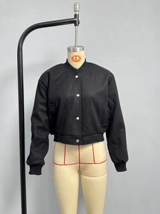Detail of black bomber jacket with silver metal buttons and ribbed texture on the hem