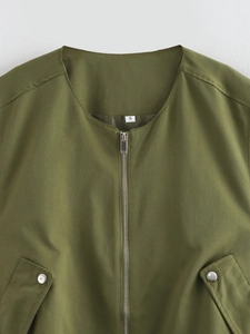 Detail of olive green V-neck vest with metal zipper and silver button pockets