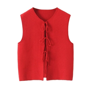 Détail du gilet en tricot rouge avec texture gaufrée et fermeture à nouettes devant