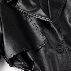 Detailed view of wide notched lapels and precise double stitching on black leather coat