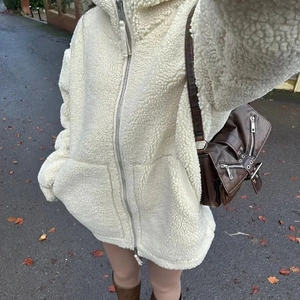 Détail de la veste en polaire ivoire oversize avec fermeture éclair en métal et capuche