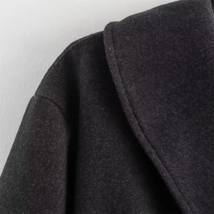 Close-up of lapel edge and shoulder stitching on a wool blend high street coat