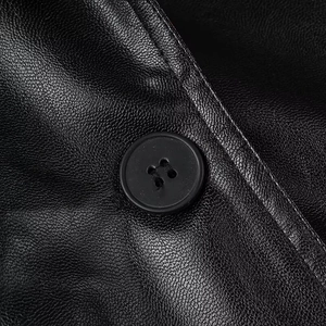 Detail of the black leather texture with lychee grain and a matching black button fastener