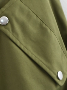 Detail of army green vest featuring twill fabric with pocket flap and silver metal snaps