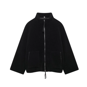 Détail d'une veste en polaire noire montrant la texture épaisse et le zip métallique