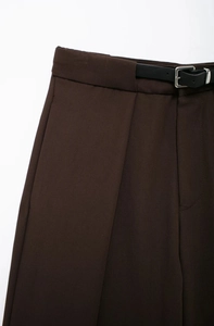 Détails du pantalon marron foncé avec ceinture en cuir noir et texture à tissage oblique