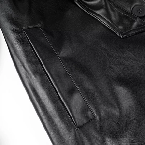 Macro shot of black leather jacket featuring pebble grain texture and button detail